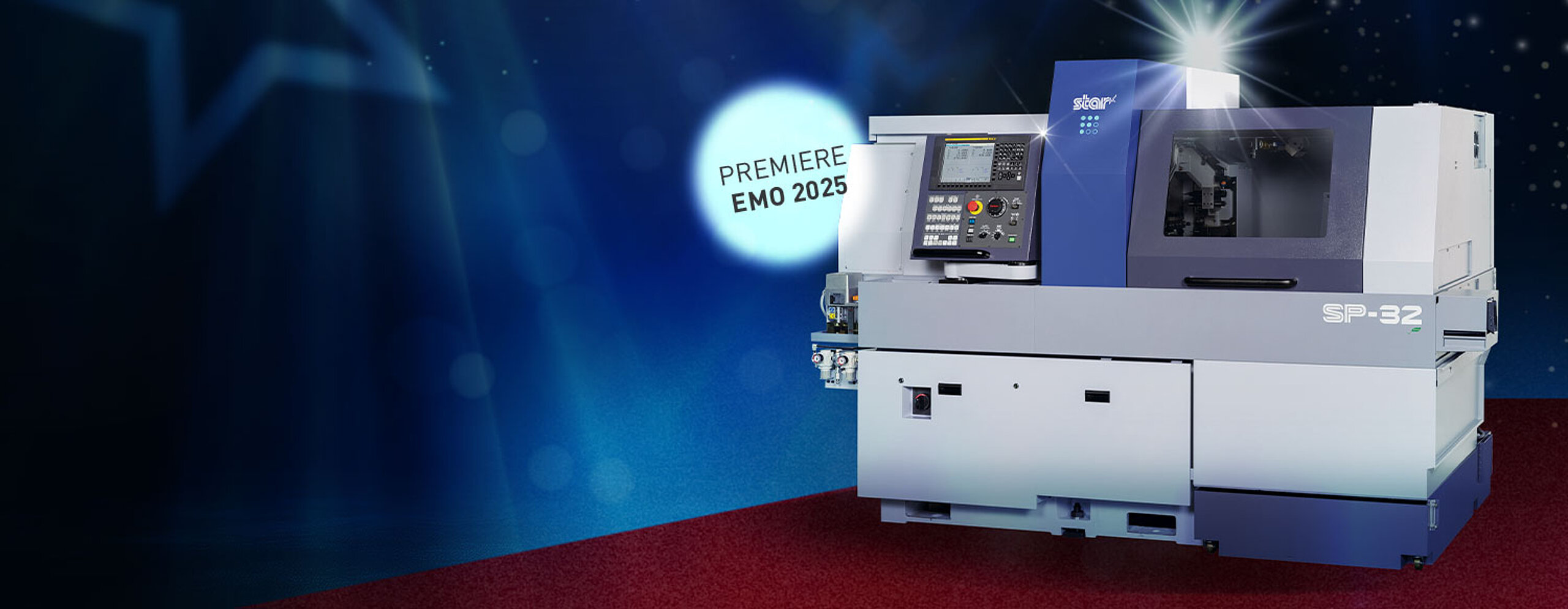 CNC-Drehautomat STAR SP-32 auf rotem Teppich vor glamourösem Hintergrund mit Lichtreflexen. Mit Hinweis "Premiere auf der EMO 2025".